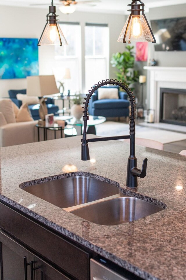 kitchen with sink, pendant lighting, and dark stone counters