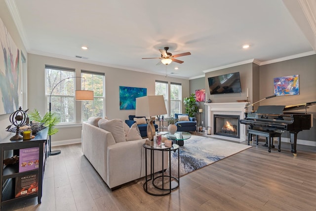 living room featuring crown molding, a wealth of natural light, and light hardwood / wood-style floors