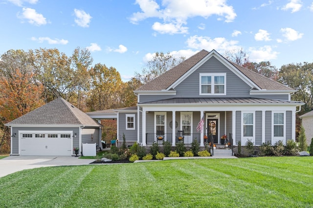 view of front of property with a garage, an outbuilding, a standing seam roof, a porch, and a front yard