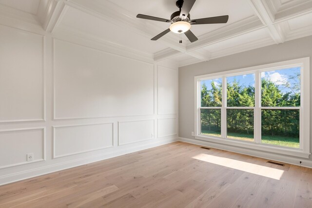 spare room with ceiling fan, coffered ceiling, light hardwood / wood-style flooring, beamed ceiling, and crown molding