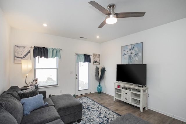 living room featuring ceiling fan and dark hardwood / wood-style floors