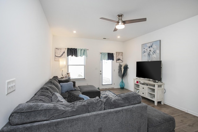 living room with dark hardwood / wood-style flooring and ceiling fan