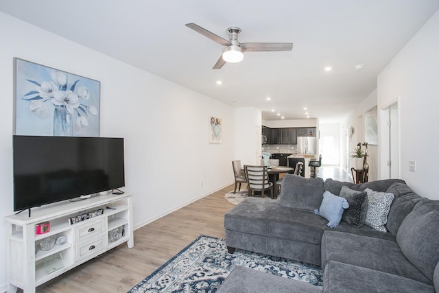 living room featuring ceiling fan and light wood-type flooring