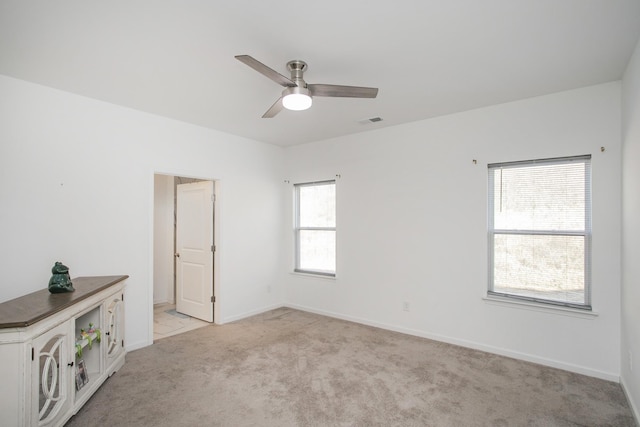 carpeted spare room with ceiling fan