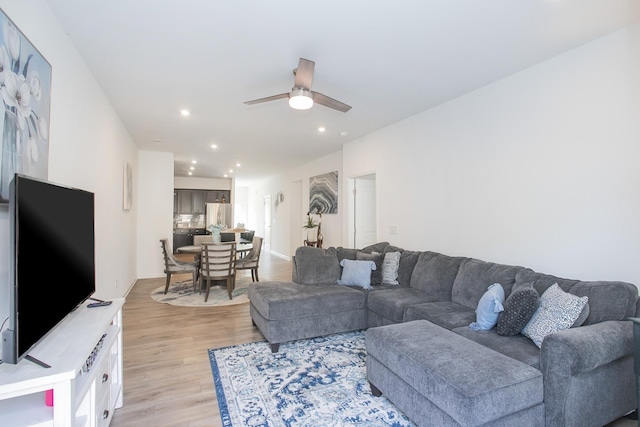 living room with ceiling fan and light hardwood / wood-style flooring