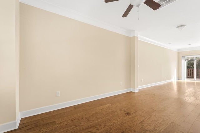 unfurnished room featuring ceiling fan with notable chandelier, hardwood / wood-style flooring, and ornamental molding