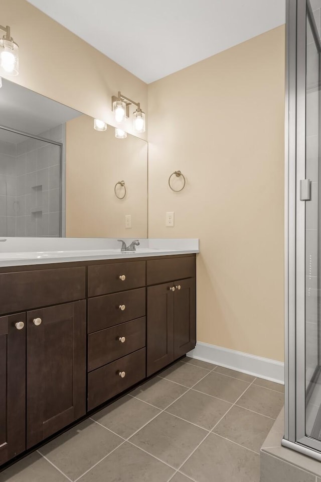 bathroom with tile patterned flooring, vanity, and walk in shower