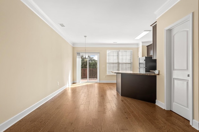 interior space with ornamental molding, dark wood-type flooring, and an inviting chandelier