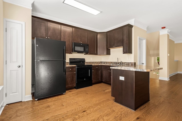 kitchen featuring black appliances, dark brown cabinetry, and crown molding