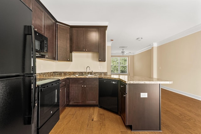 kitchen featuring black appliances, sink, crown molding, light hardwood / wood-style flooring, and kitchen peninsula