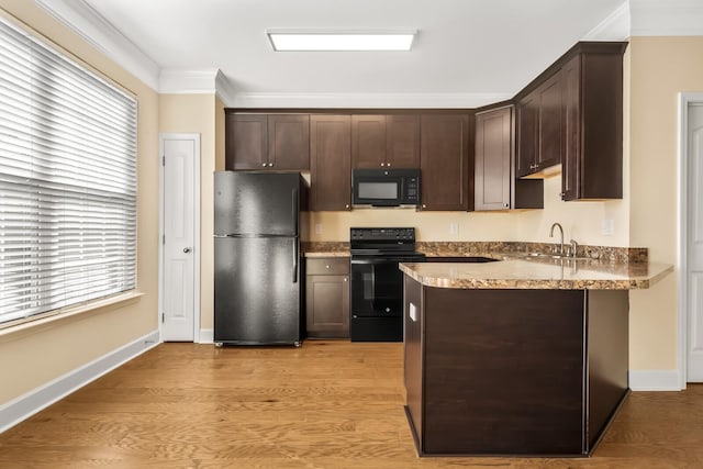 kitchen with black appliances, dark brown cabinets, and sink