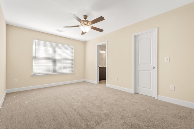 unfurnished bedroom featuring light carpet, ensuite bathroom, and ceiling fan