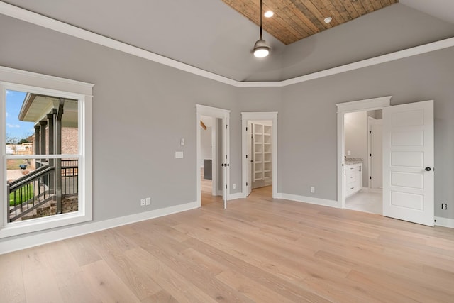 unfurnished bedroom with connected bathroom, a spacious closet, wooden ceiling, a high ceiling, and light hardwood / wood-style floors