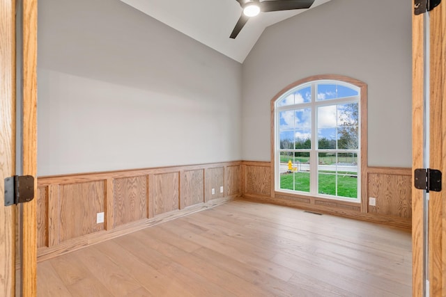 empty room featuring ceiling fan, lofted ceiling, and light hardwood / wood-style flooring