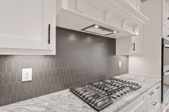 kitchen featuring backsplash, white cabinetry, and stainless steel appliances