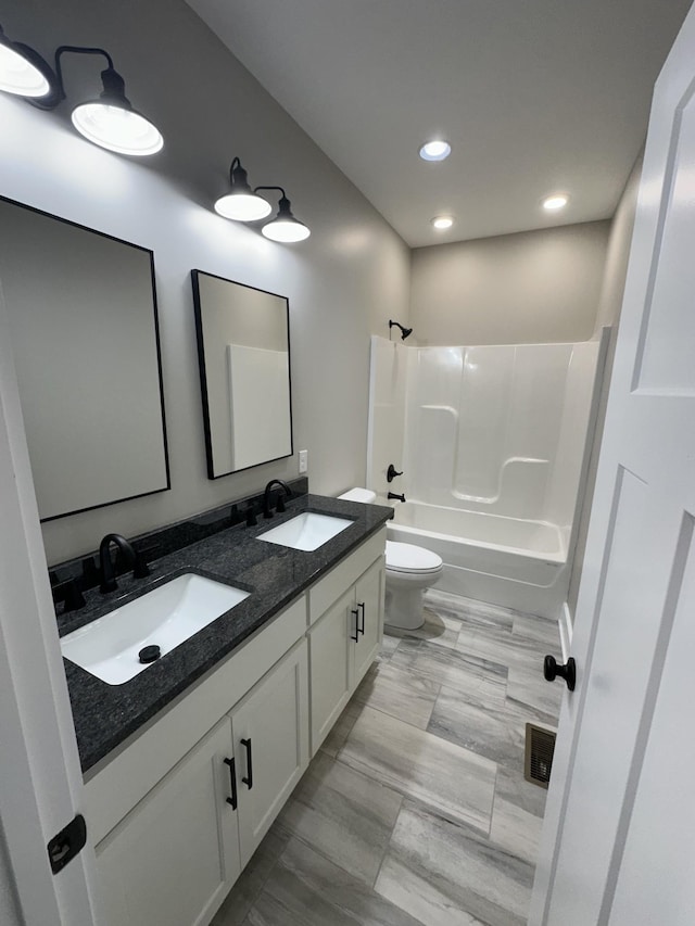 full bathroom with toilet, vanity, and tub / shower combination