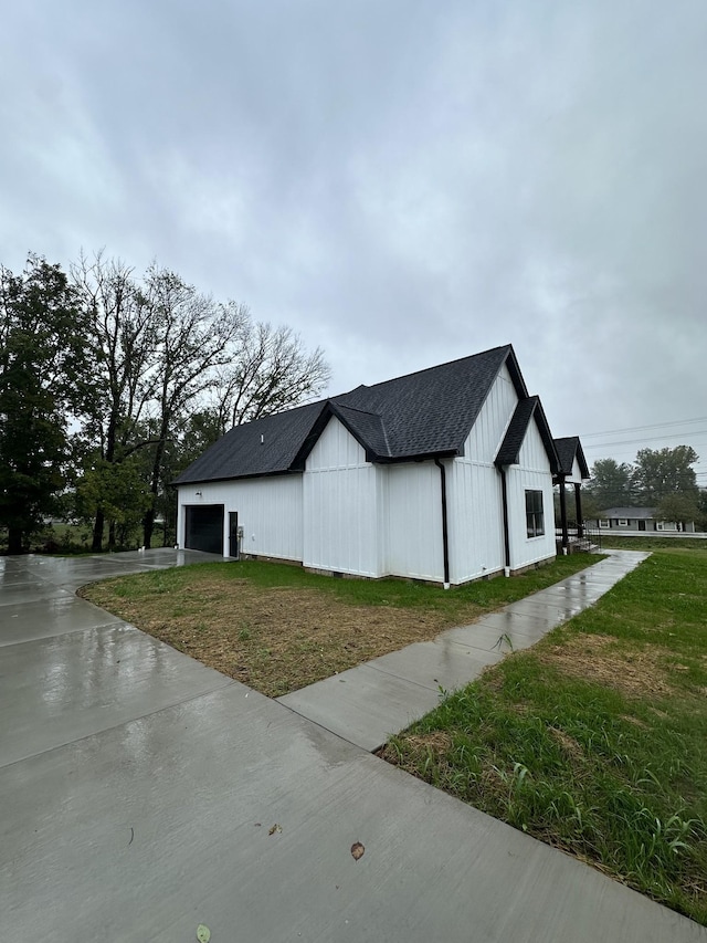 view of side of home featuring a lawn and a garage