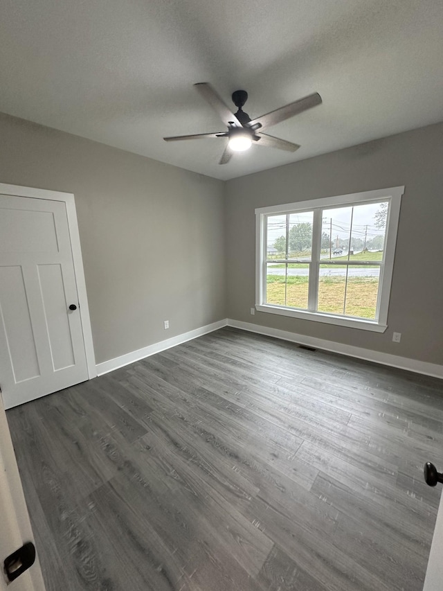 unfurnished room featuring ceiling fan and dark hardwood / wood-style floors