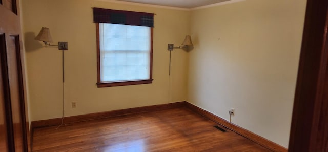 unfurnished room with hardwood / wood-style flooring, a healthy amount of sunlight, and ornamental molding