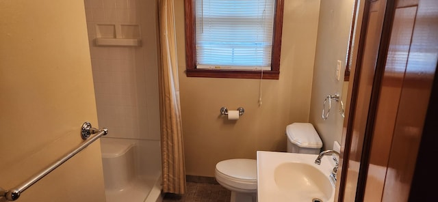 bathroom featuring a shower with curtain, toilet, and sink