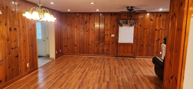 foyer entrance with wood walls and hardwood / wood-style flooring