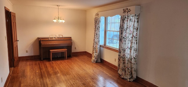 miscellaneous room with a chandelier, dark hardwood / wood-style floors, and ornamental molding