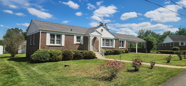 view of front of house with brick siding, driveway, a front yard, and an attached carport