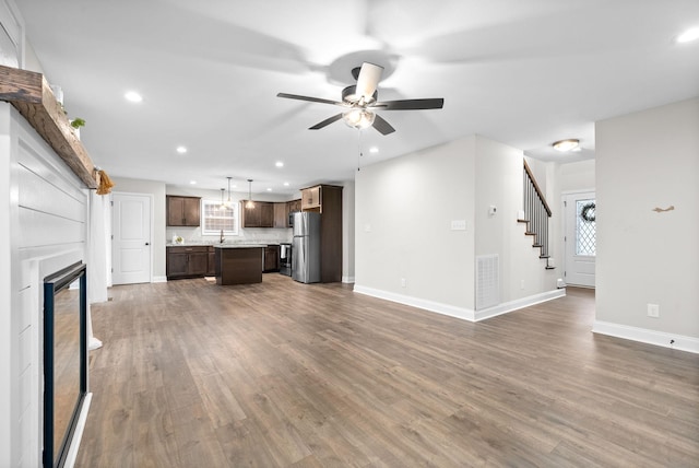 unfurnished living room with ceiling fan and dark wood-type flooring