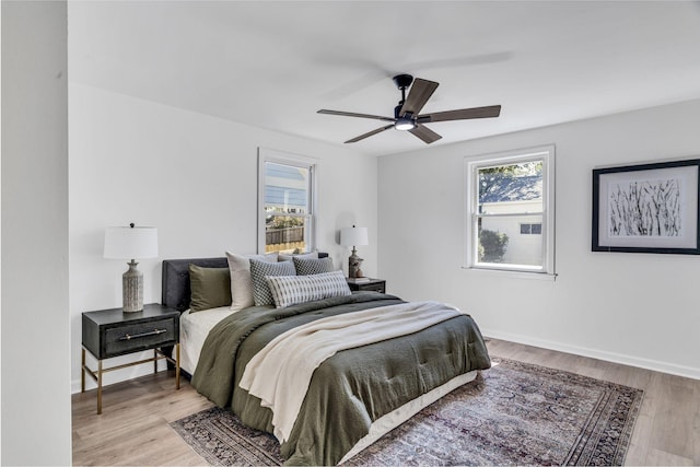 bedroom with multiple windows, ceiling fan, and light hardwood / wood-style flooring