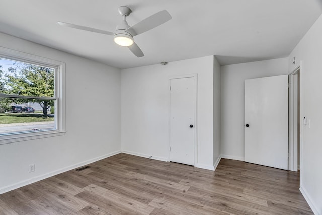 unfurnished bedroom featuring ceiling fan, light wood-type flooring, and a closet