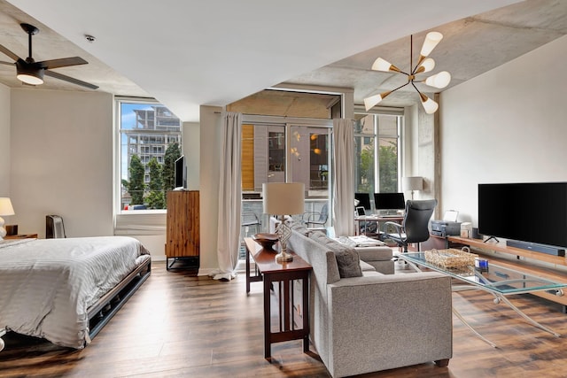 bedroom with ceiling fan with notable chandelier, expansive windows, and dark wood-type flooring