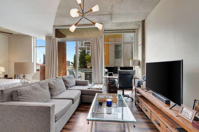 living room featuring a notable chandelier, dark hardwood / wood-style floors, and a wall of windows