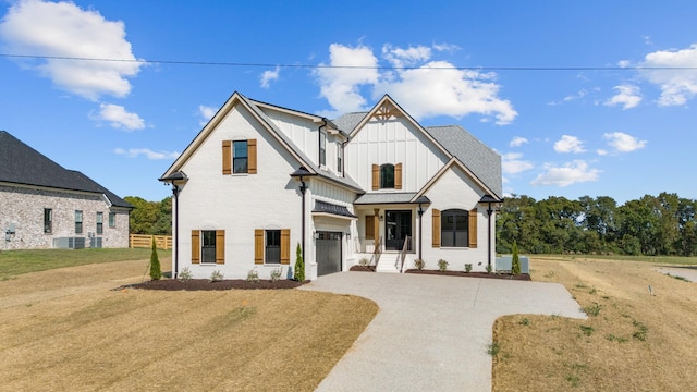 modern inspired farmhouse with a garage and a front lawn