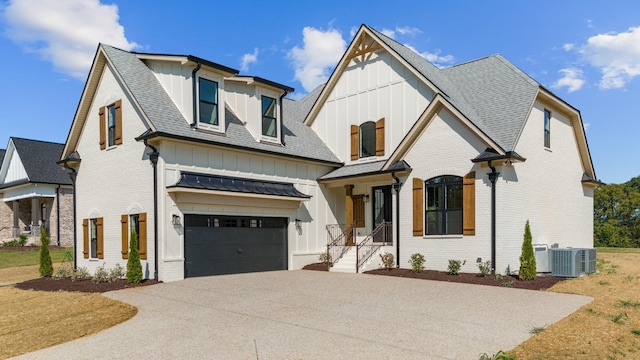 view of front of home with central AC unit and a garage