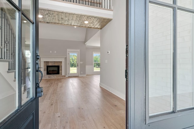 entryway featuring a fireplace, light wood-type flooring, and lofted ceiling