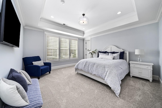 bedroom with carpet floors, ornamental molding, and a tray ceiling