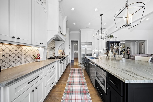 kitchen featuring tasteful backsplash, a large island, white cabinetry, and hanging light fixtures