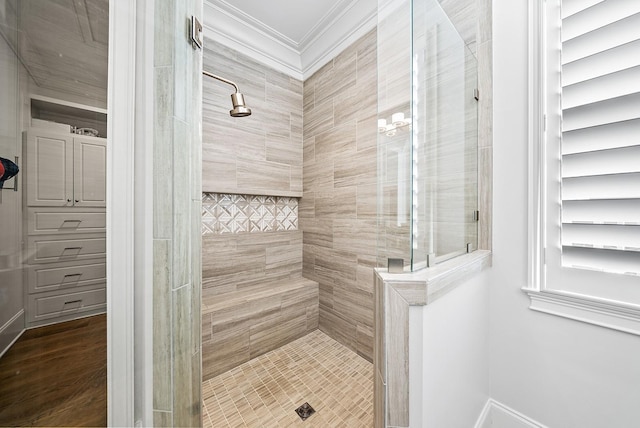 bathroom with tiled shower and crown molding