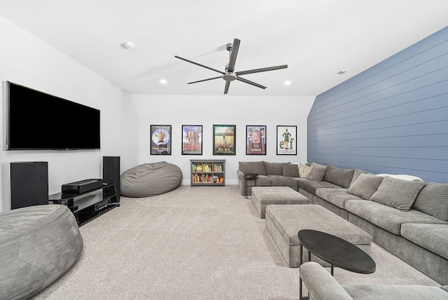 carpeted living room featuring wooden walls and ceiling fan