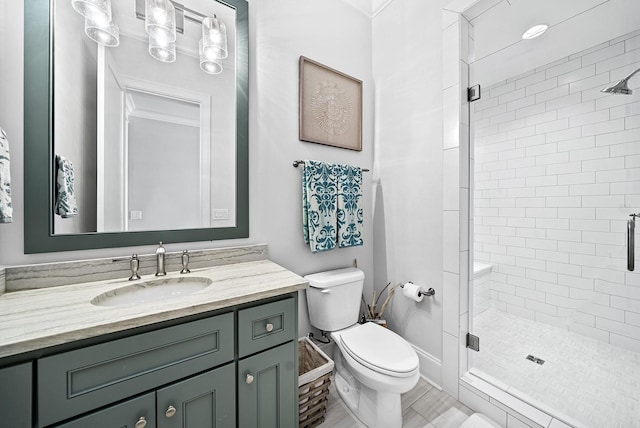 bathroom with vanity, toilet, and a shower with door