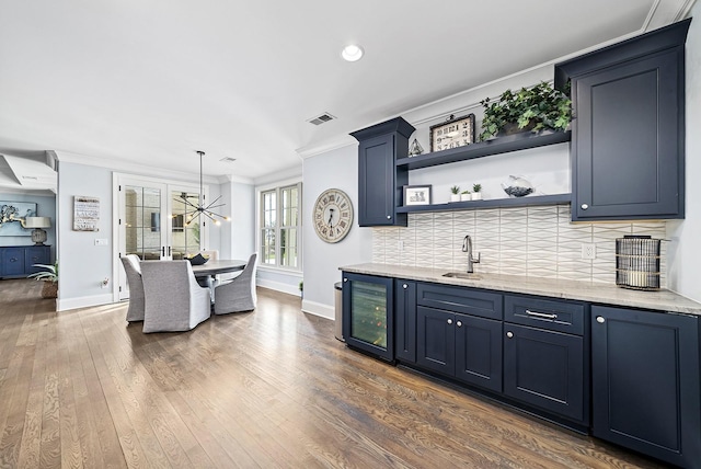 bar featuring sink, dark wood-type flooring, crown molding, decorative light fixtures, and decorative backsplash