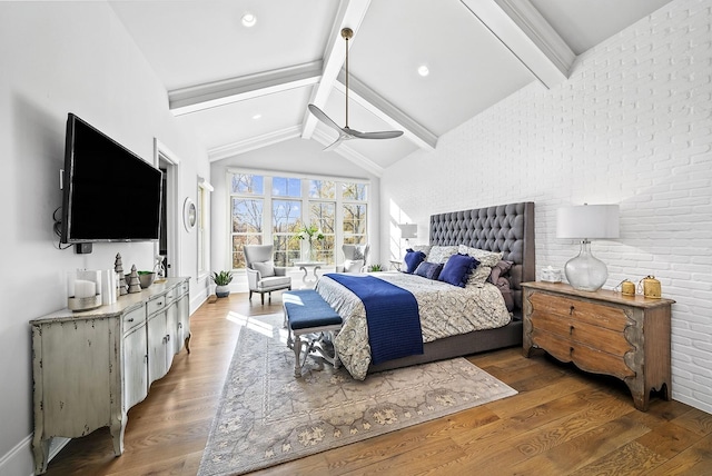 bedroom with hardwood / wood-style flooring, vaulted ceiling with beams, ceiling fan, and brick wall