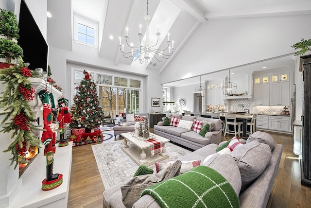 living room featuring a notable chandelier, light hardwood / wood-style floors, beam ceiling, and high vaulted ceiling