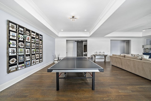 recreation room featuring a tray ceiling, crown molding, and dark hardwood / wood-style floors