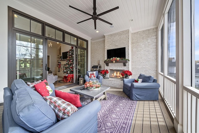 sunroom with ceiling fan, a fireplace, and wood ceiling