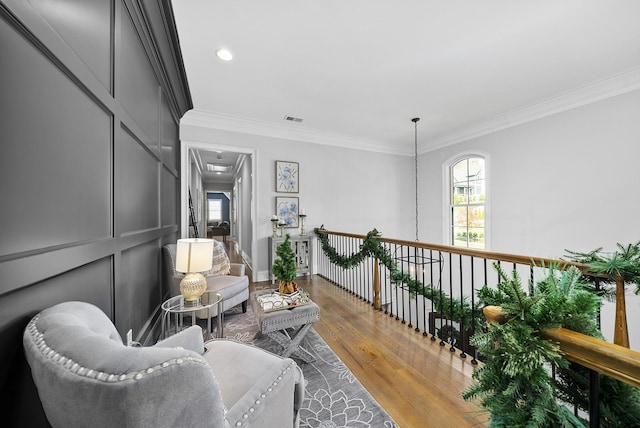 living area featuring crown molding and hardwood / wood-style flooring