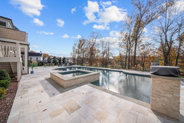 view of swimming pool featuring a patio area and an in ground hot tub