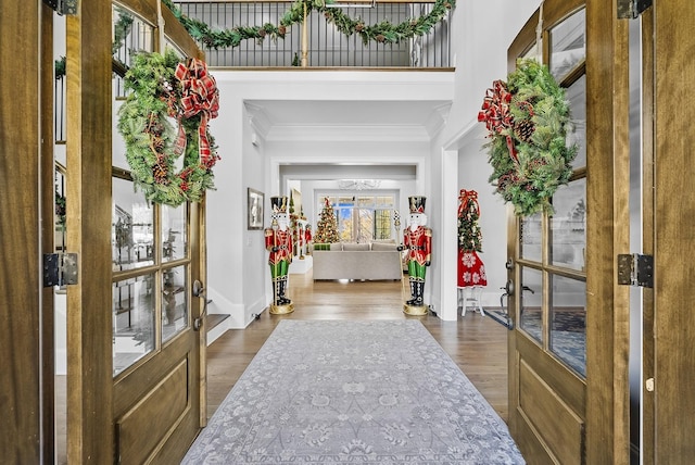 entryway with ornamental molding, dark wood-type flooring, and french doors