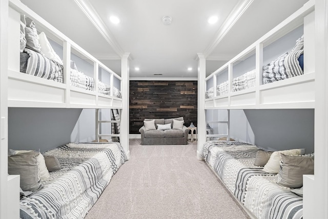 bedroom with carpet floors, wooden walls, and ornamental molding