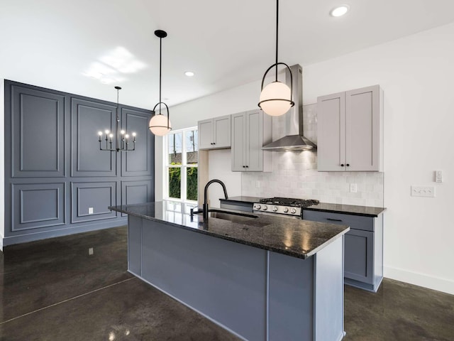 kitchen with wall chimney range hood, hanging light fixtures, gray cabinetry, and sink